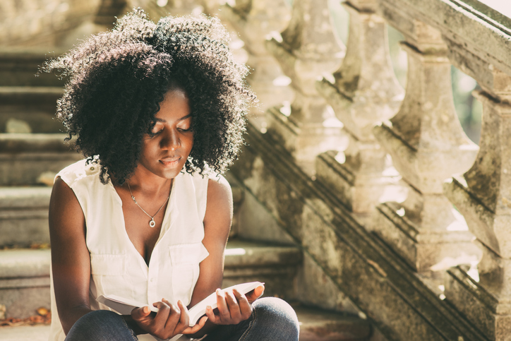 A young black woman reading books for aspiring medics
