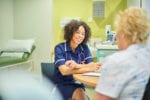 a female nurse talks to a senior patient at an a&e clinic, medical news