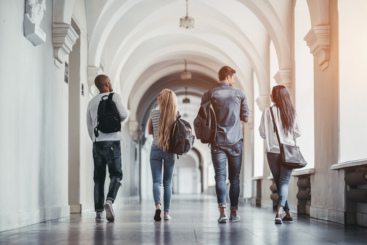 A group of students walk down a hallway at university together