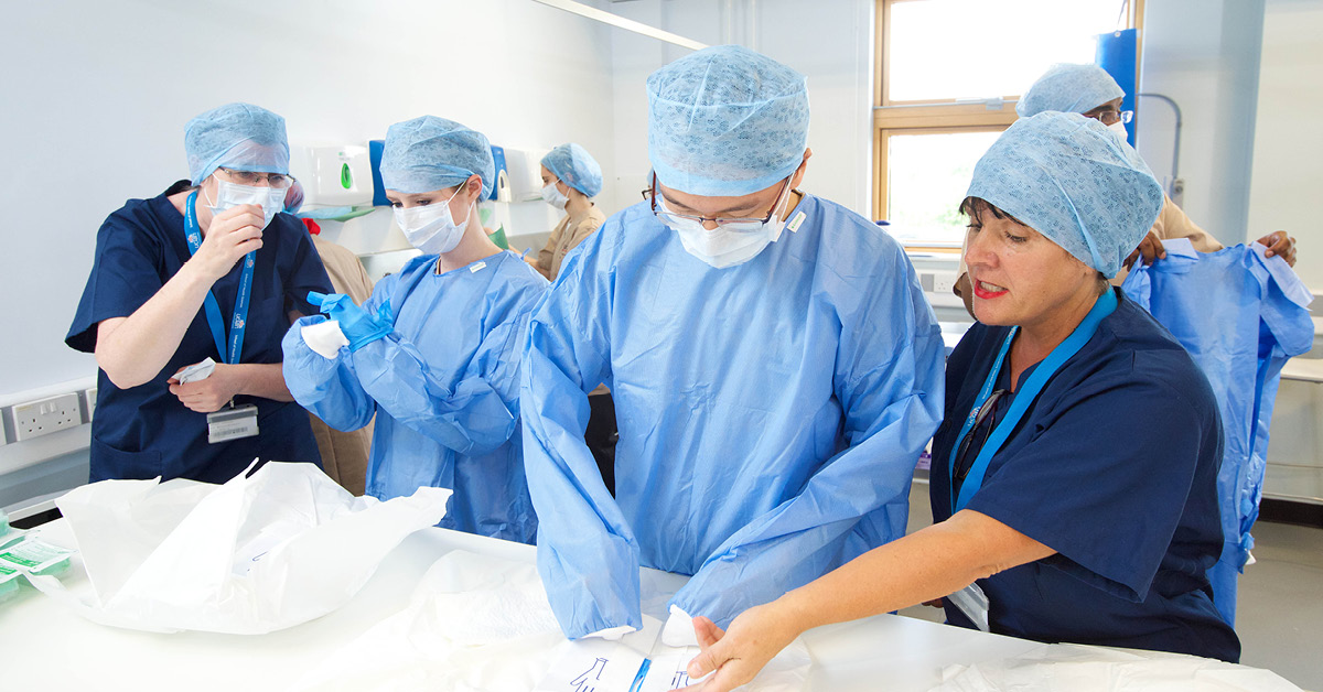 Doctors stand over a table