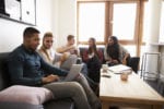 A group of university students sit in a communal area and socialise