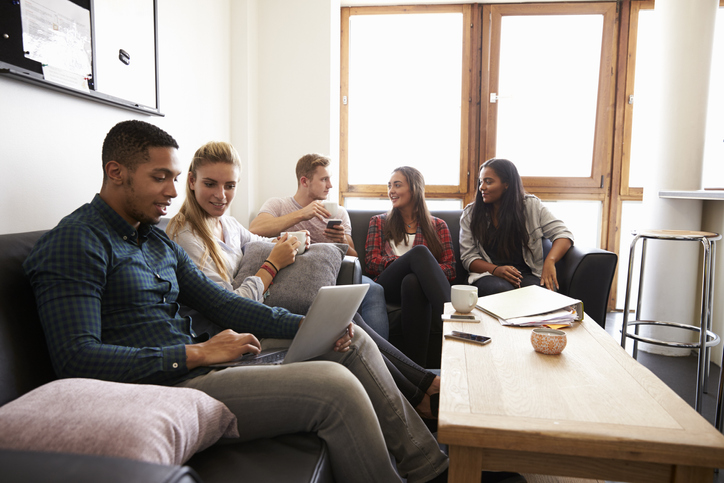 A group of university students sit in a communal area and socialise