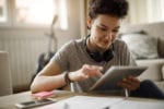 A student sits looking at her ipad